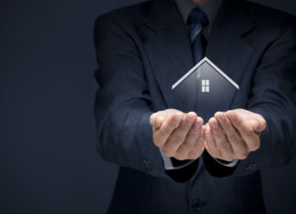 home qui tient une maison pour illustrer une assurance habitation